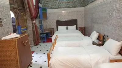 a bedroom with two beds with white sheets at Riad Carole - Perfect for Families & Groups in Marrakech