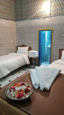 a room with two beds and a plate of food on a table at Riad Carole - Perfect for Families & Groups in Marrakech