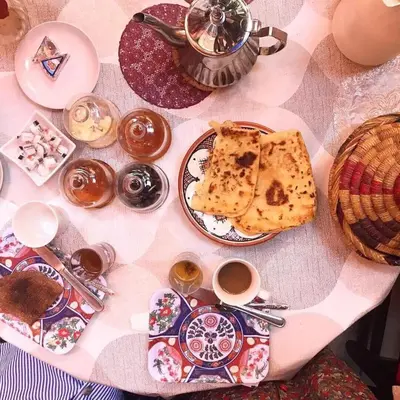 a table topped with plates of food and cups of coffee at Riad Carole - Perfect for Families & Groups in Marrakech