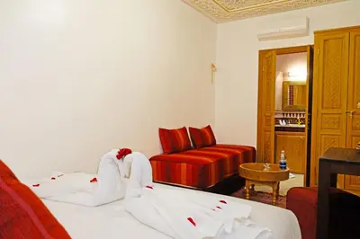 a hotel room with two beds and a couch at Riad ZANOUBA in Marrakech