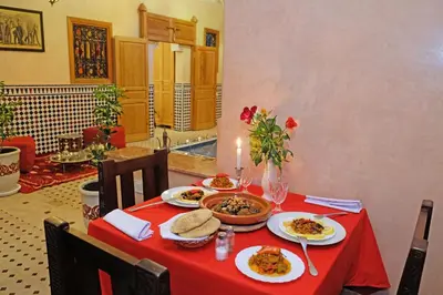 a table with plates of food on a red table cloth at Riad ZANOUBA in Marrakech