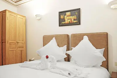 a bedroom with two beds with white towels on them at Riad ZANOUBA in Marrakech