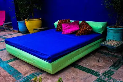 a green bed with colorful pillows on it at Riad Rêve d Antan , Real Dream in Marrakech