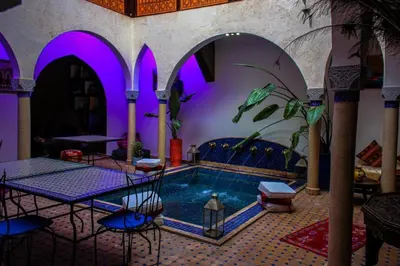 a swimming pool in a room with purple lighting at Riad Rêve d Antan , Real Dream in Marrakech
