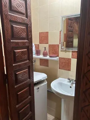 a bathroom with a sink and a wooden door at RIAD ZAKARYA in Marrakech