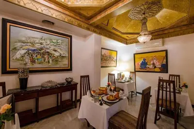 a dining room with a table and chairs and a ceiling at Riad Palais Didier Six in Marrakech