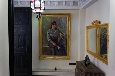 a painting of a man sitting on a chair in a room at Riad Palais Didier Six in Marrakech