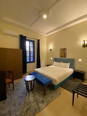 a bedroom with a bed and a blue bench at Comfy Colonial Apartments in Marrakech