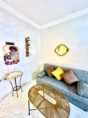 a living room with a blue couch and a table at Lovely 2-bedroom appartement in Marrakech