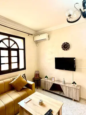 a living room with a couch and a flat screen tv at Lovely 2-bedroom appartement in Marrakech