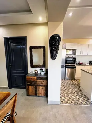 a living room with a black mask on the wall at Moderne, lumineux & spacieux avec balcon -Central -Wifi-Smart TV-Clim in Marrakech