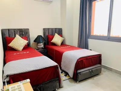 two beds sitting next to each other in a room at Moderne, lumineux & spacieux avec balcon -Central -Wifi-Smart TV-Clim in Marrakech