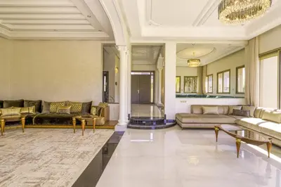 a large living room with couches and a chandelier at Villa Naciri en plein golf avec vue sur Atlas in Marrakech