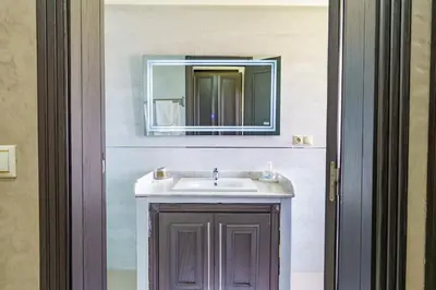 a bathroom with a sink and a mirror at Villa Naciri en plein golf avec vue sur Atlas in Marrakech