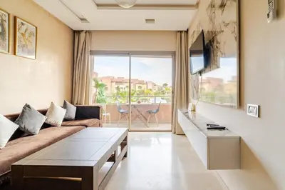 a living room with a couch and a table at Cozy Atlas Golf Studio Prestigia Marrakech in Marrakech