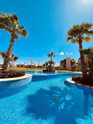 a swimming pool with palm trees in a resort at Cozy Atlas Golf Studio Prestigia Marrakech in Marrakech