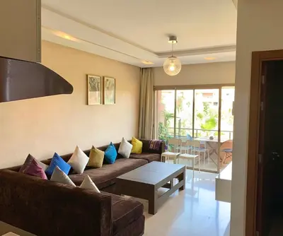 a living room with a couch and a table at Cozy Atlas Golf Studio Prestigia Marrakech in Marrakech