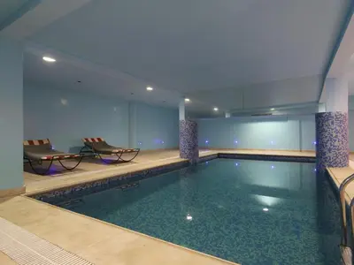a swimming pool in a hotel room with two chairs at Ghita Appartement in Marrakech