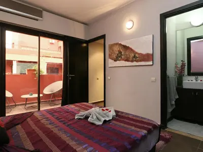 a bedroom with a bed and a bathroom with a sink at Ghita Appartement in Marrakech