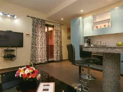 a kitchen and living room with a counter and chairs at Ghita Appartement in Marrakech
