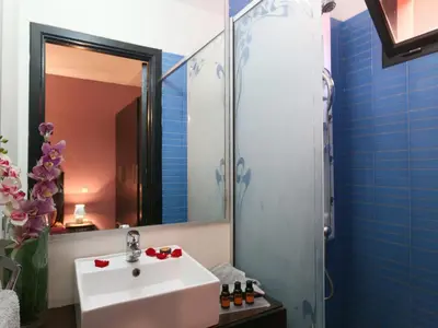 a bathroom with a sink and a shower with a mirror at Ghita Appartement in Marrakech