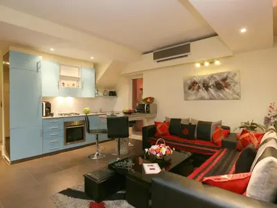 a living room with a couch and a kitchen at Ghita Appartement in Marrakech
