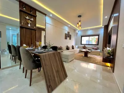 a dining room and living room with a table and chairs at Appartement marrakech de lux in Marrakech
