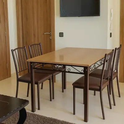 a dining room table with chairs and a television at Appartement Nour 5 Marrakech Centre Gueliz avec piscine in Marrakech