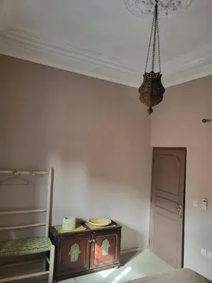 a room with a table and a chandelier at Riad MsHolidays bassin privatisé Marrakech in Marrakech