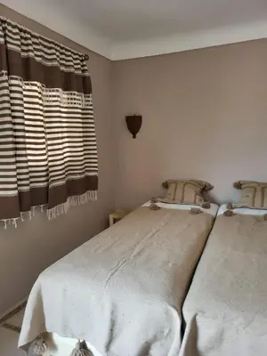 a bedroom with two beds and a window at Riad MsHolidays bassin privatisé Marrakech in Marrakech