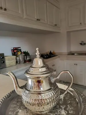 a silver tea kettle on a glass tray on a table at Riad MsHolidays bassin privatisé Marrakech in Marrakech