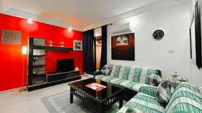 a living room with a green couch and red walls at BAGATELLE STUDIO GUELIZ in Marrakech