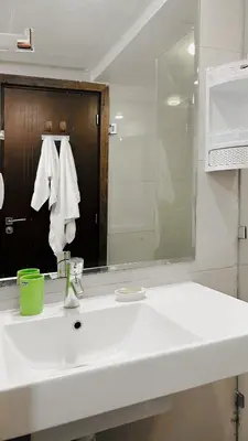 a bathroom with a white sink and a mirror at BAGATELLE STUDIO GUELIZ in Marrakech