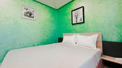 a bedroom with a white bed with green walls at BAGATELLE STUDIO GUELIZ in Marrakech