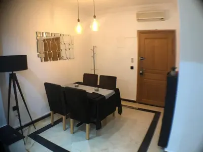 a dining room with a table and black chairs at Beautiful Luxury 2 bedrooms Apartment in Marrakech in Marrakech