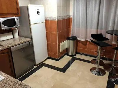 a kitchen with a refrigerator and a table and a stool at Beautiful Luxury 2 bedrooms Apartment in Marrakech in Marrakech