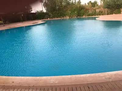 a large swimming pool with blue water at Beautiful Luxury 2 bedrooms Apartment in Marrakech in Marrakech