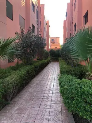 a stone walkway in a city with tall buildings at Beautiful Luxury 2 bedrooms Apartment in Marrakech in Marrakech