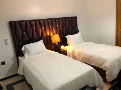 a hotel room with two beds and a lamp at Beautiful Luxury 2 bedrooms Apartment in Marrakech in Marrakech