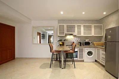a kitchen with a table and chairs and a refrigerator at Appartement moderne en City Center Marrakech-Gueliz in Marrakech