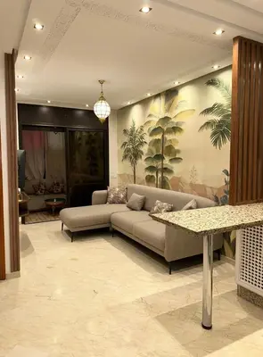 a living room with a couch and a table at Appartement moderne en City Center Marrakech-Gueliz in Marrakech