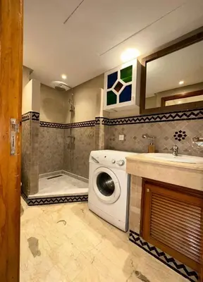a bathroom with a washing machine and a shower at Appartement moderne en City Center Marrakech-Gueliz in Marrakech