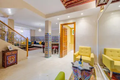 a living room with yellow chairs and a staircase at Appartement moderne en City Center Marrakech-Gueliz in Marrakech