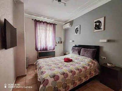 a bedroom with a bed with a red stuffed animal on it at Résidence NAJD C - Appartement T2 in Marrakech