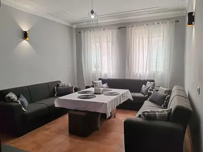 a living room with a table and two couches at Résidence NAJD C - Appartement T2 in Marrakech