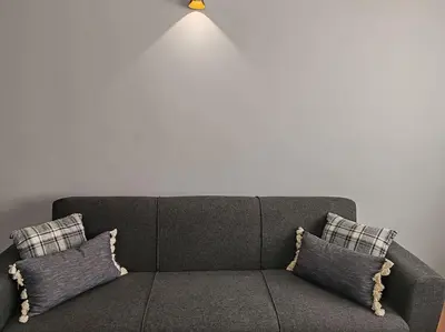 a couch with two pillows and a light above it at Résidence NAJD C - Appartement T2 in Marrakech
