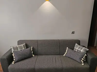 a gray couch with pillows in a living room at Résidence NAJD C - Appartement T2 in Marrakech