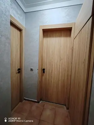 a wooden door in a room with a floor at Résidence NAJD C - Appartement T2 in Marrakech