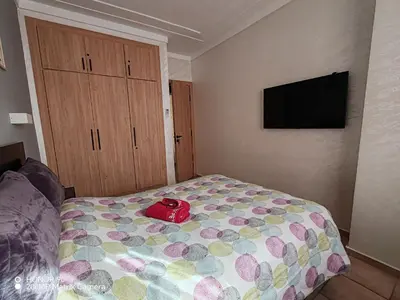 a bedroom with a bed with a red bag on it at Résidence NAJD C - Appartement T2 in Marrakech