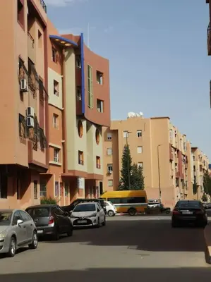 a group of cars parked on a street next to buildings at Résidence NAJD C - Appartement T2 in Marrakech